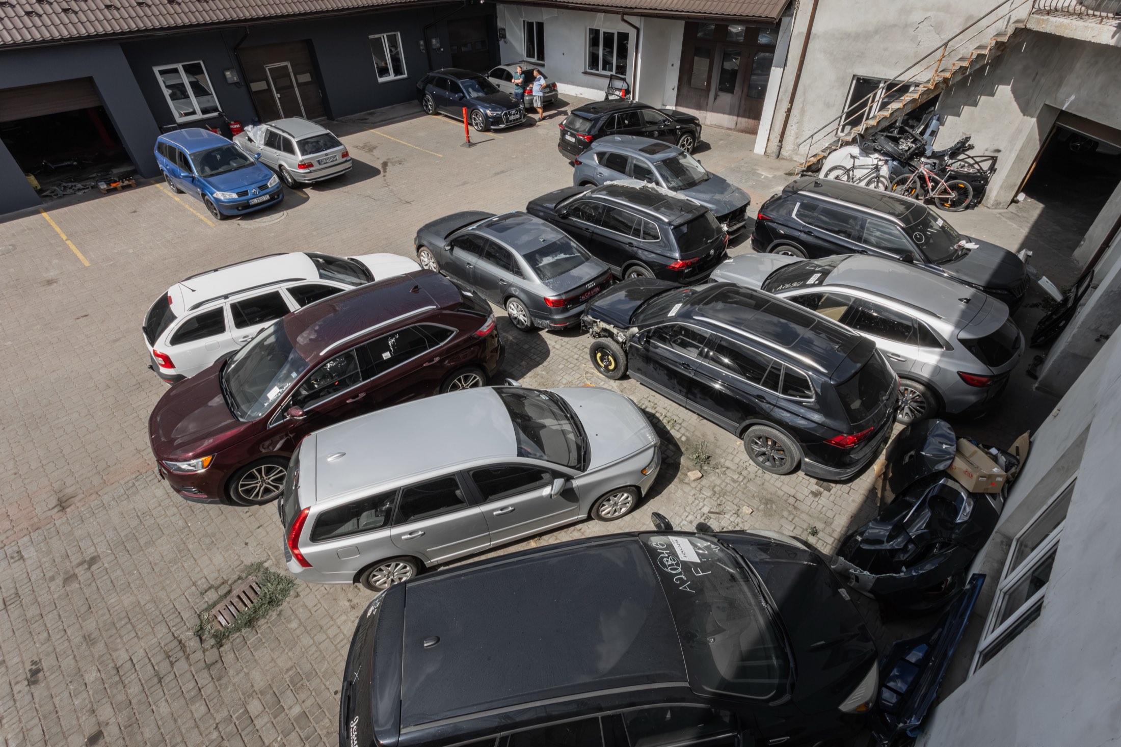 Двір автосервісу, заповнений автомобілями клієнтів